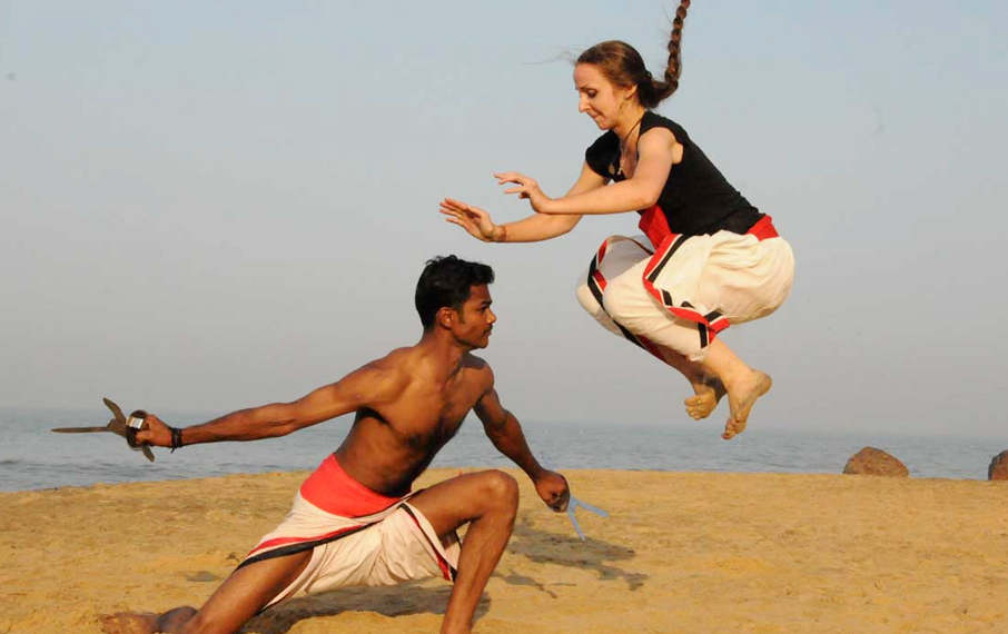 Kalarippayattu practitioners demonstrating a weapon defense technique on the Kerala coast